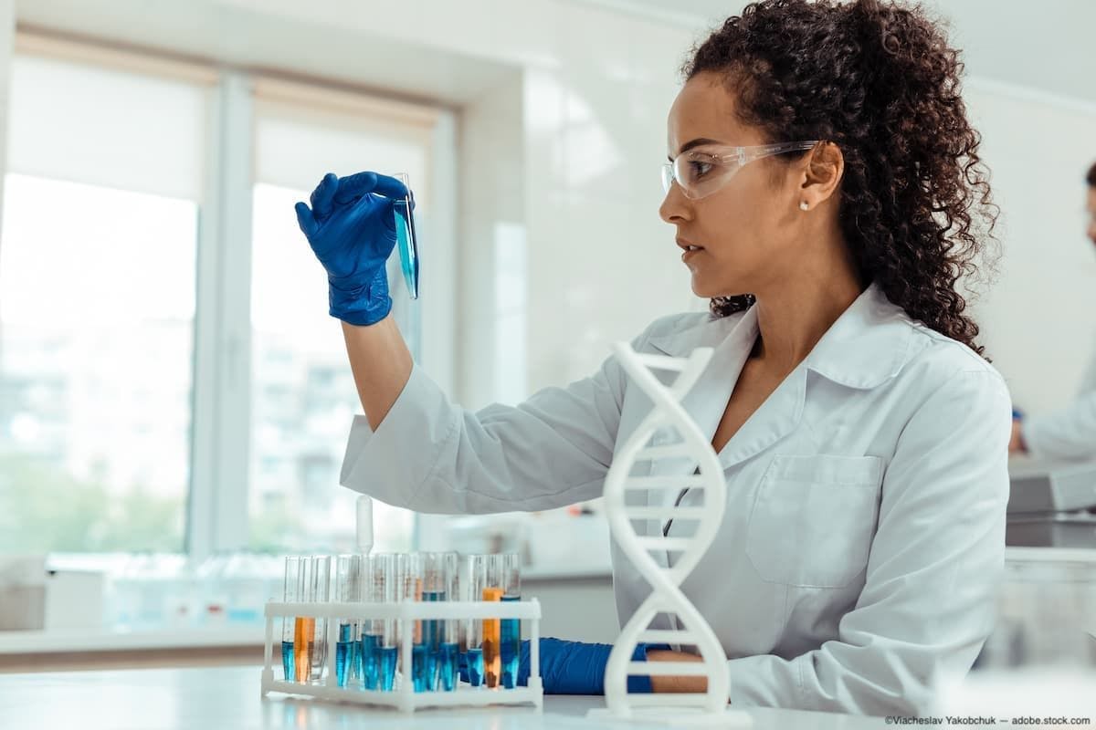Woman in lab looking into test tub Image Credit: AdobeStock/ViacheslavYakobchuk
