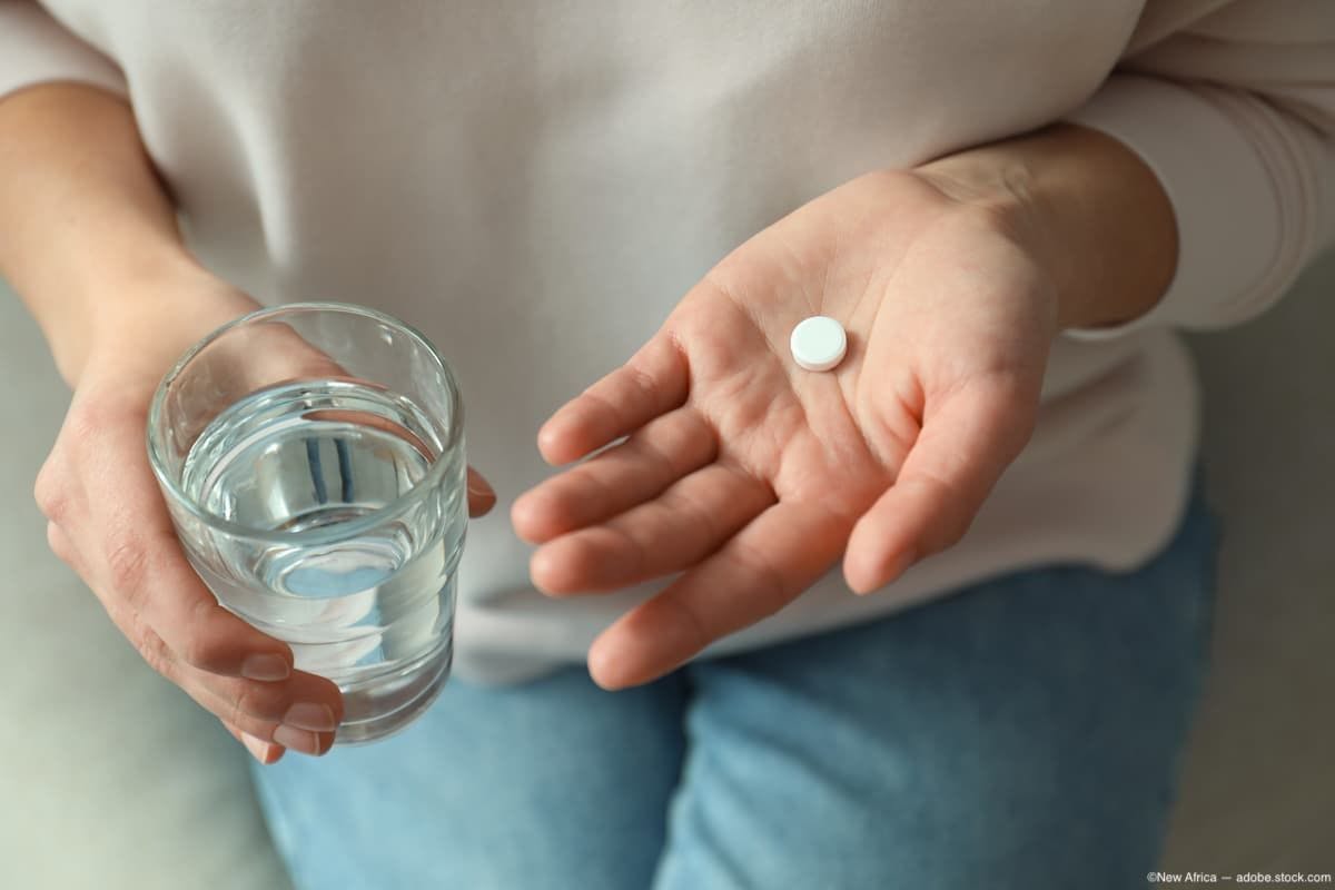 Woman holding pill and glass of water while sitting down Image credit: ©New Africa - adobe.stock.com