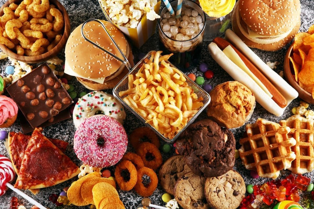Array of fast food, sugary sweets, pizza Image Credit: AdobeStock/beats_