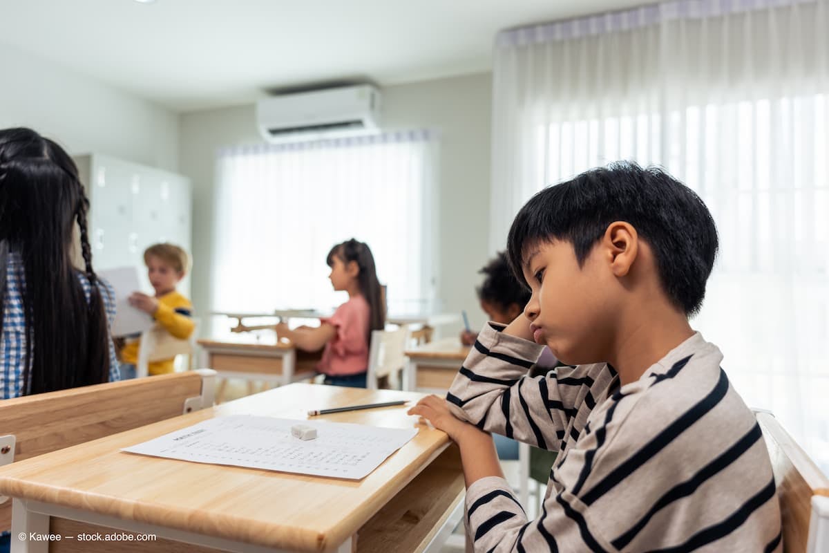 Asian young boy student doing an exam test at elementary school. (Adobe Stock / Kawee)