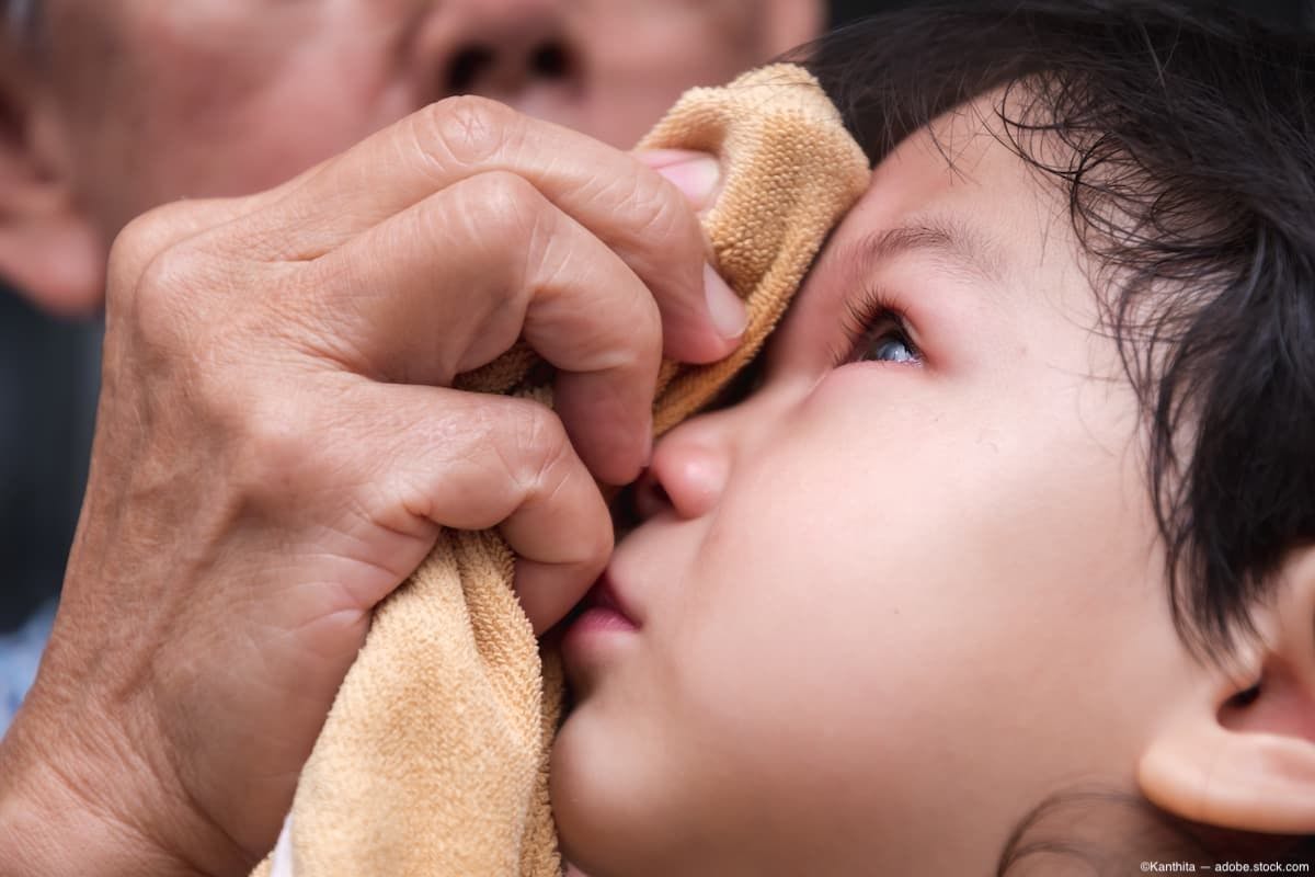 Adult holding towel on child's eye Image Credit: AdobeStock/Kanthita