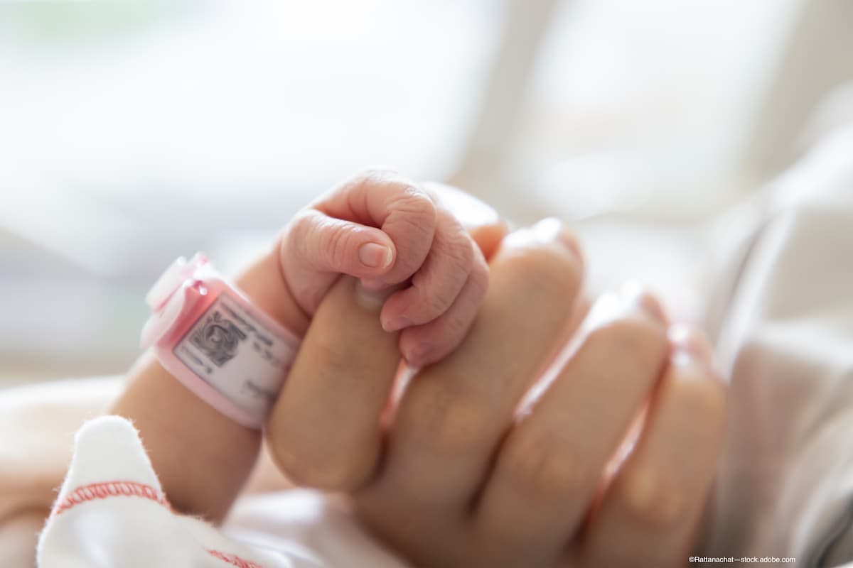 Preterm infant holds mother's hand