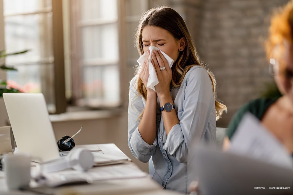 Business woman in office sneezing into tissue Image Credit: © Drazen - stock.adobe.com