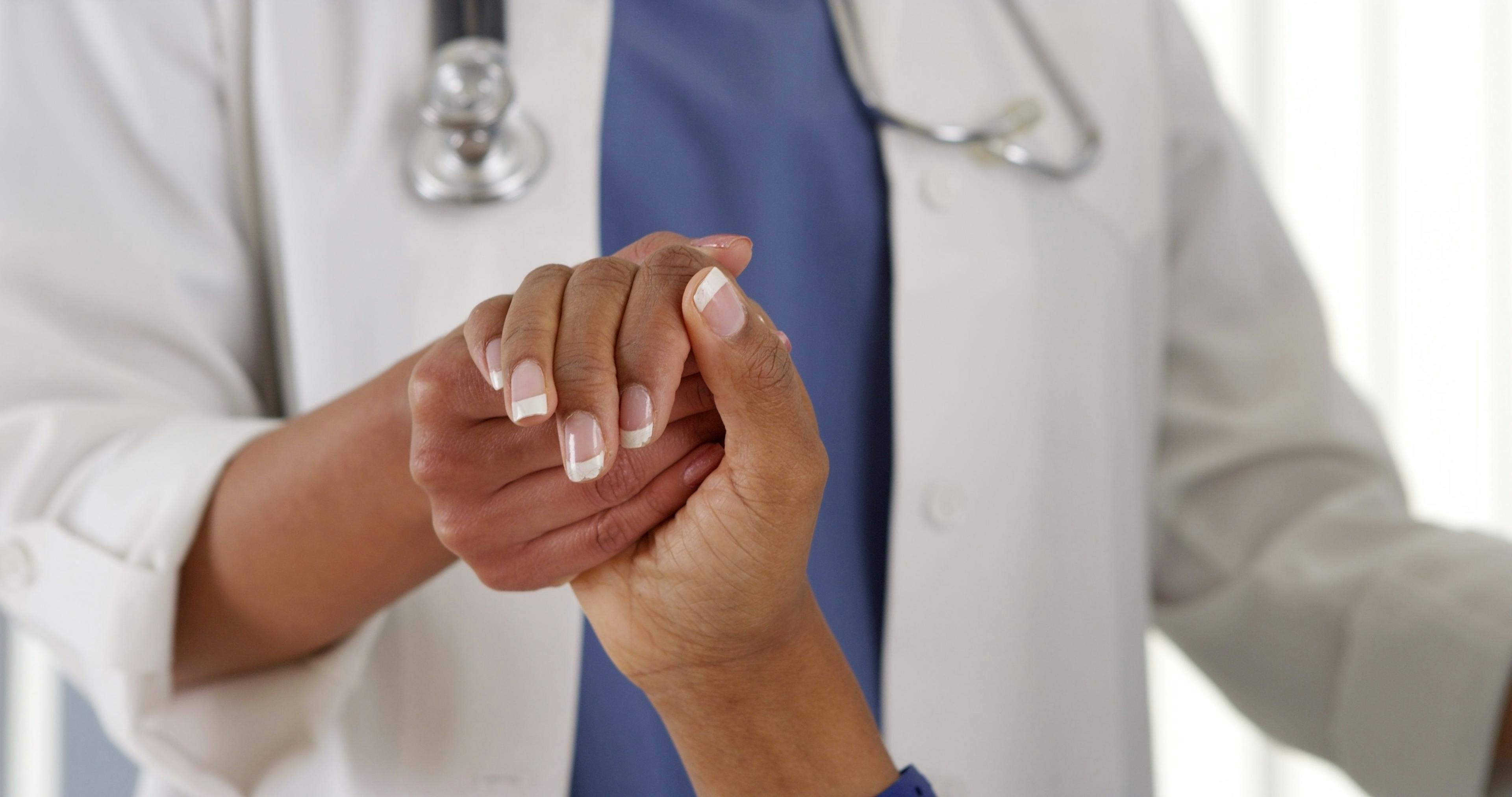 A doctor wearing a white coat reaches his hand inside