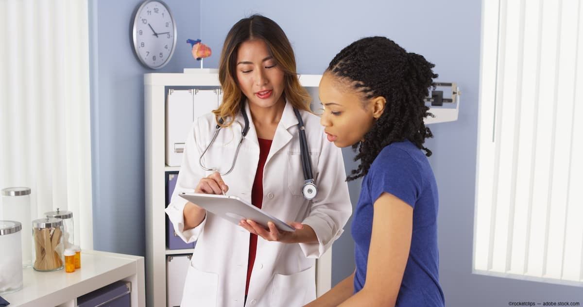 Practitioner, left, going over results on tablet with patient sitting down Image Credit: AdobeStock/rocketclips