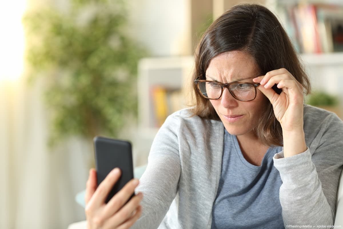Woman wearing glasses holding phone Image Credit: AdobeStock/PheelingsMedia