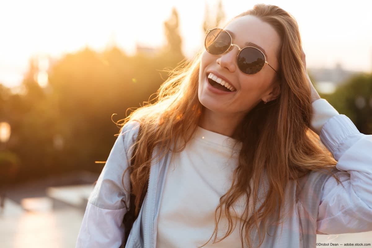 Woman smiling outside with sunglasses on Image credit: ©Drobot Dean - adobe.stock.com