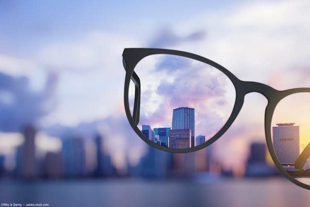 a pair of glasses clarifying a blurry skyline through its lenses Image Credit: © Who is Danny - stock.adobe.com